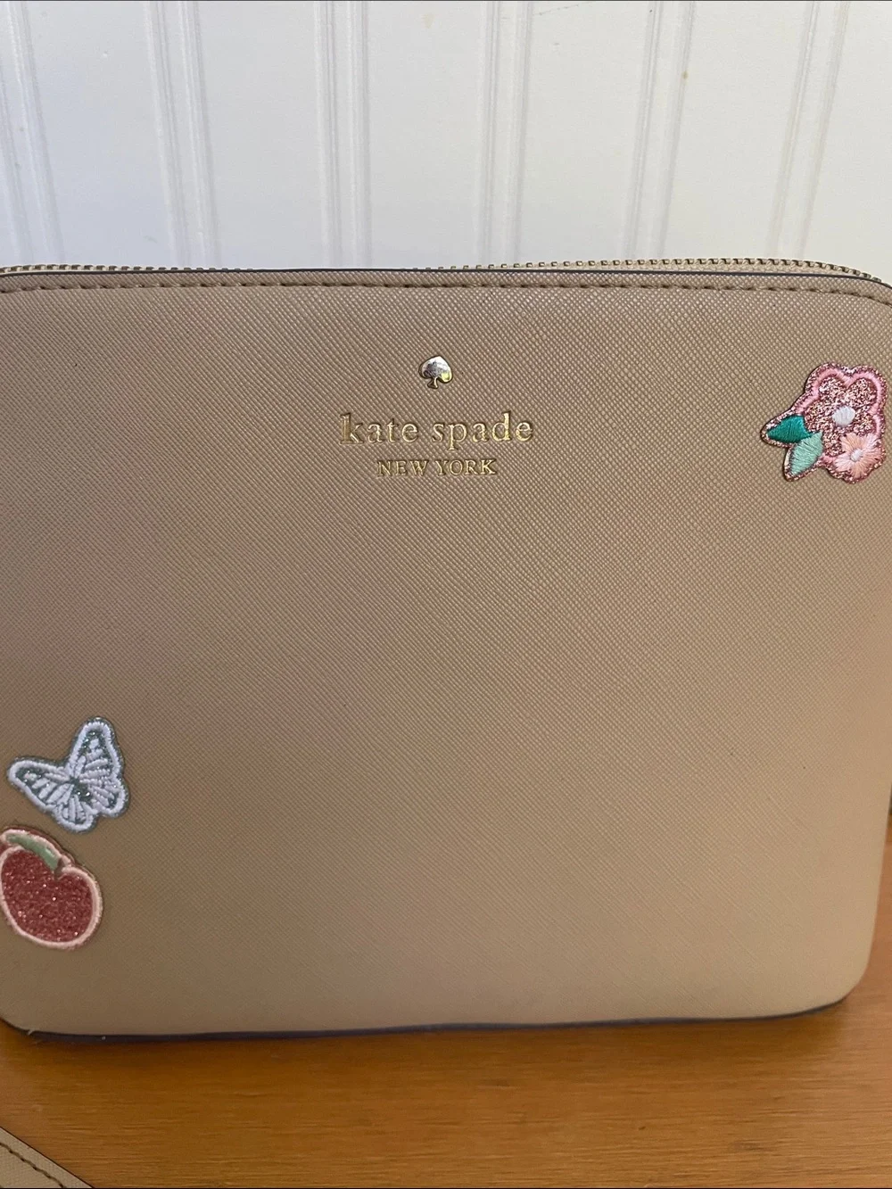 Kate Spade tan crossbody with floral, butterfly and fruit accents